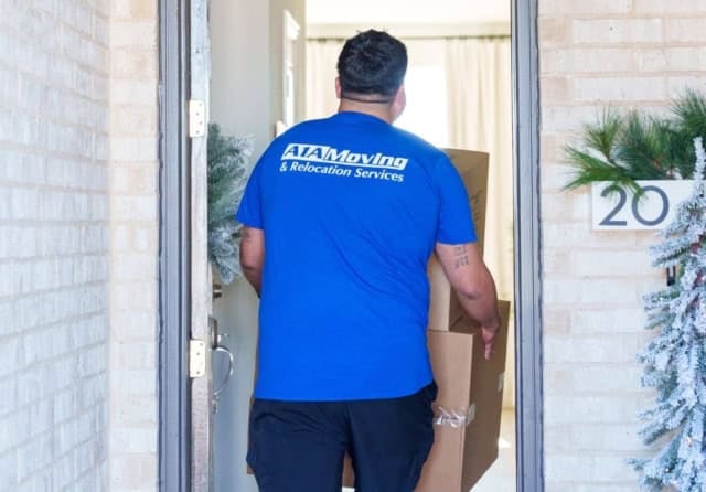 A1A mover carrying moving boxes through a home's front door