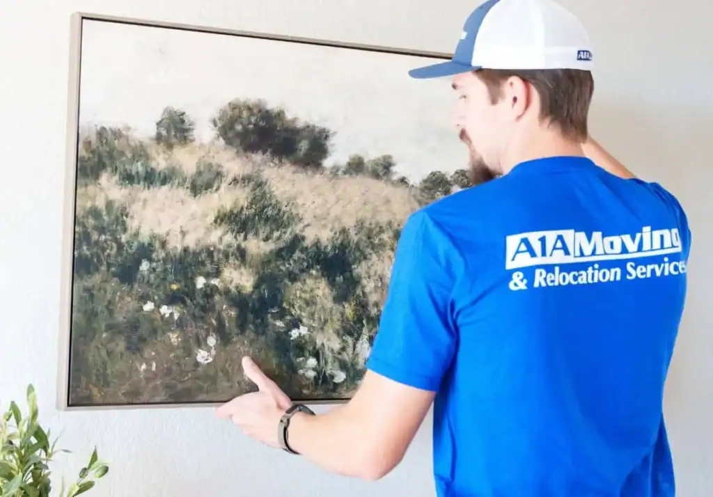 A1A mover carrying a framed landscape painting