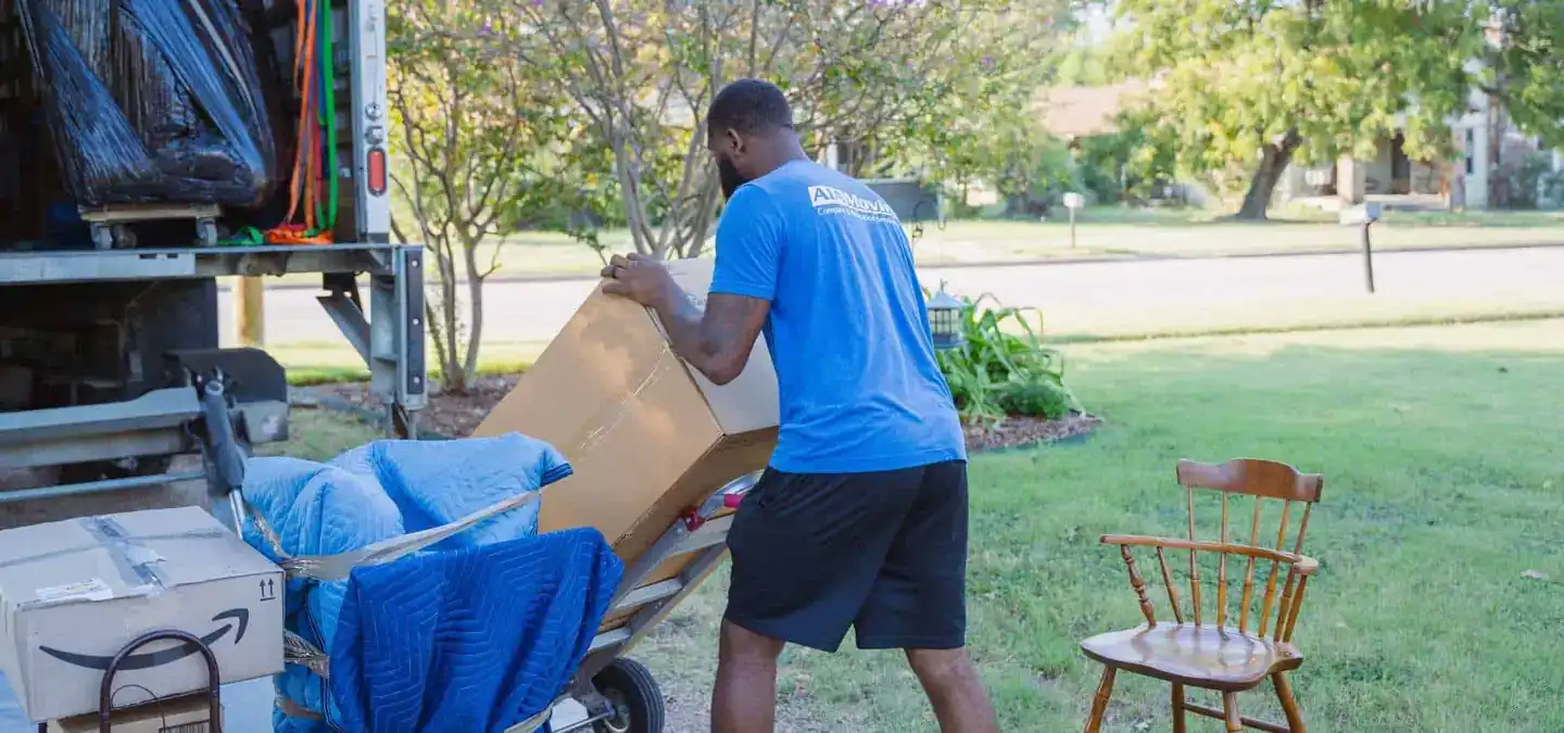 A1A mover loading a box onto a dolly next to the moving truck