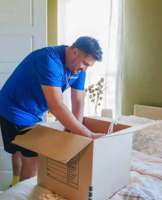 A1A mover packing a box in a bedroom