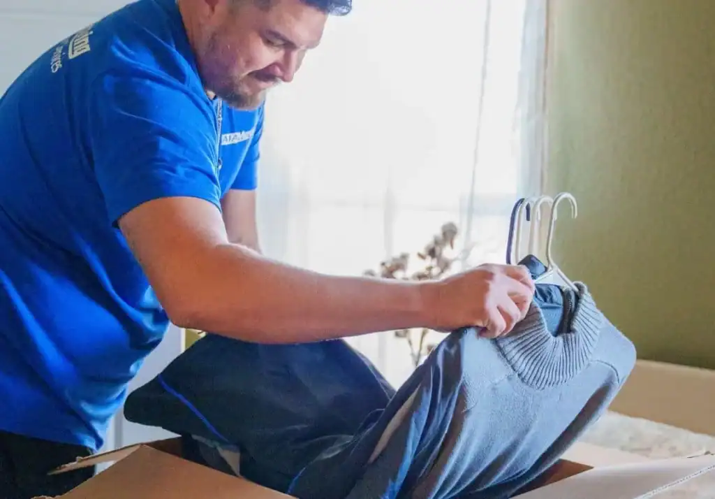 A1A mover packing hanging clothes into a wardrobe box