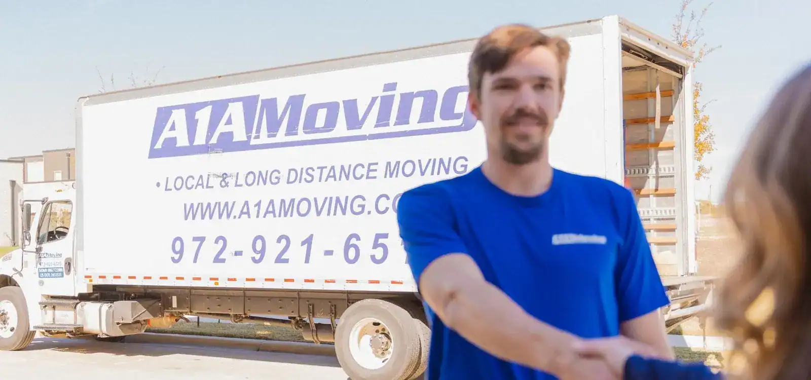 A1A mover shaking hands with a customer beside the moving truck