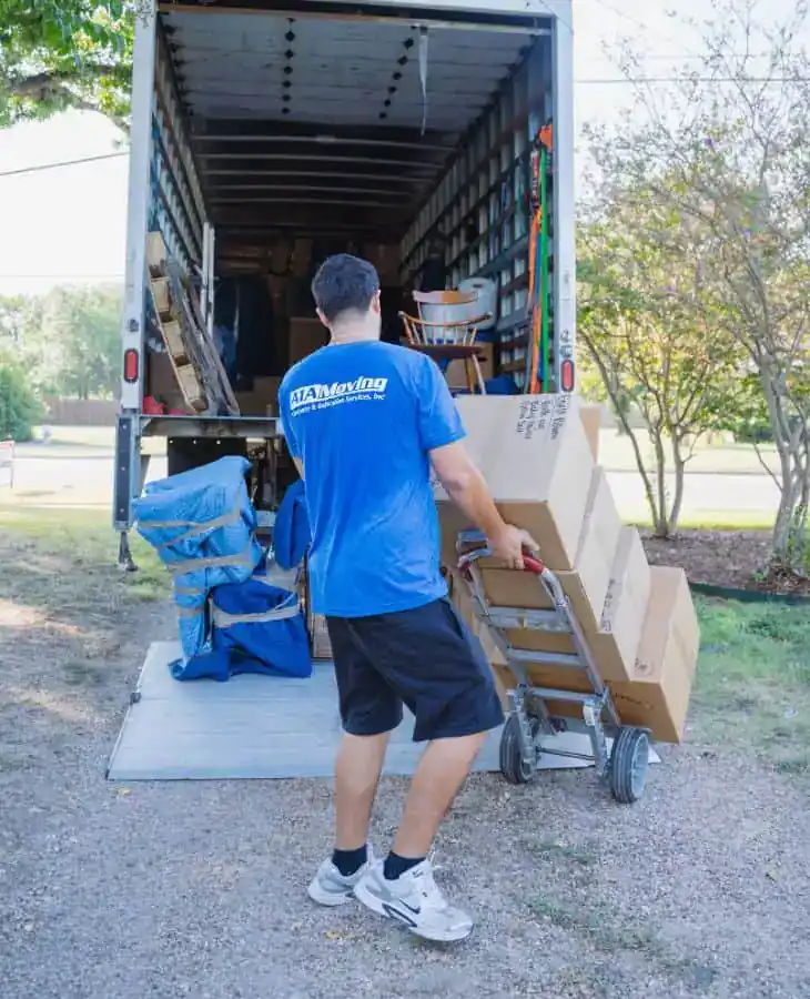 A1A mover wheeling a stack of boxes to the truck on a hand truck