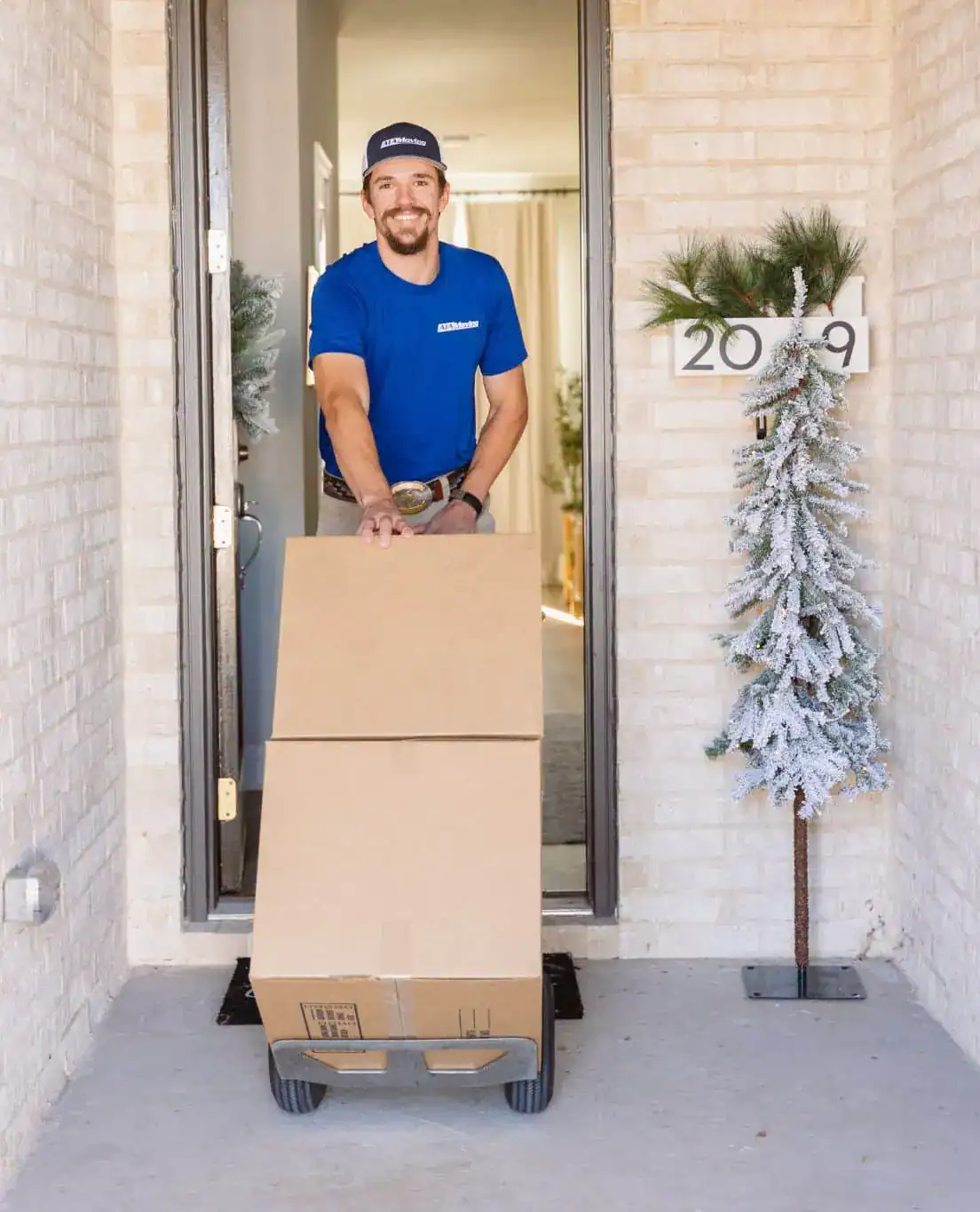 A1A mover wheeling boxes on a hand truck out of a front door