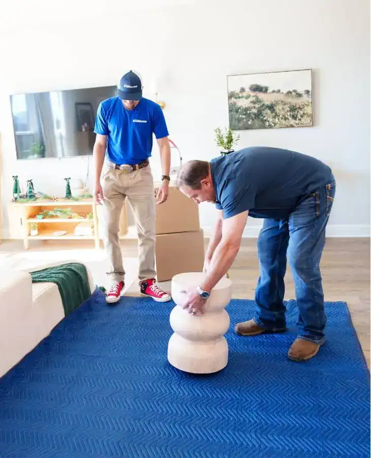 A1A movers laying moving pads on the floor to protect it while moving furniture