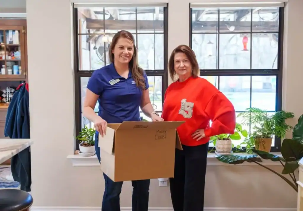 A1A team member and a customer holding a moving box inside a home