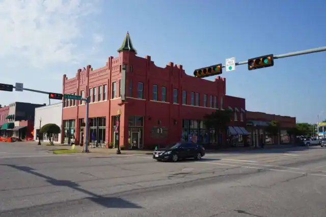 Historic red brick building at a downtown intersection on W Ennis Ave
