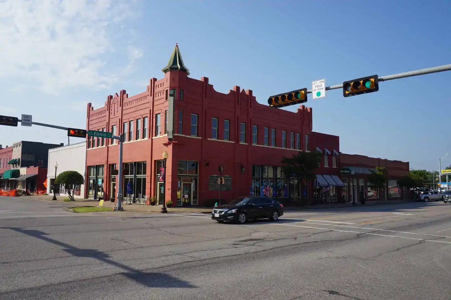 Historic red brick building at a downtown intersection on W Ennis Ave