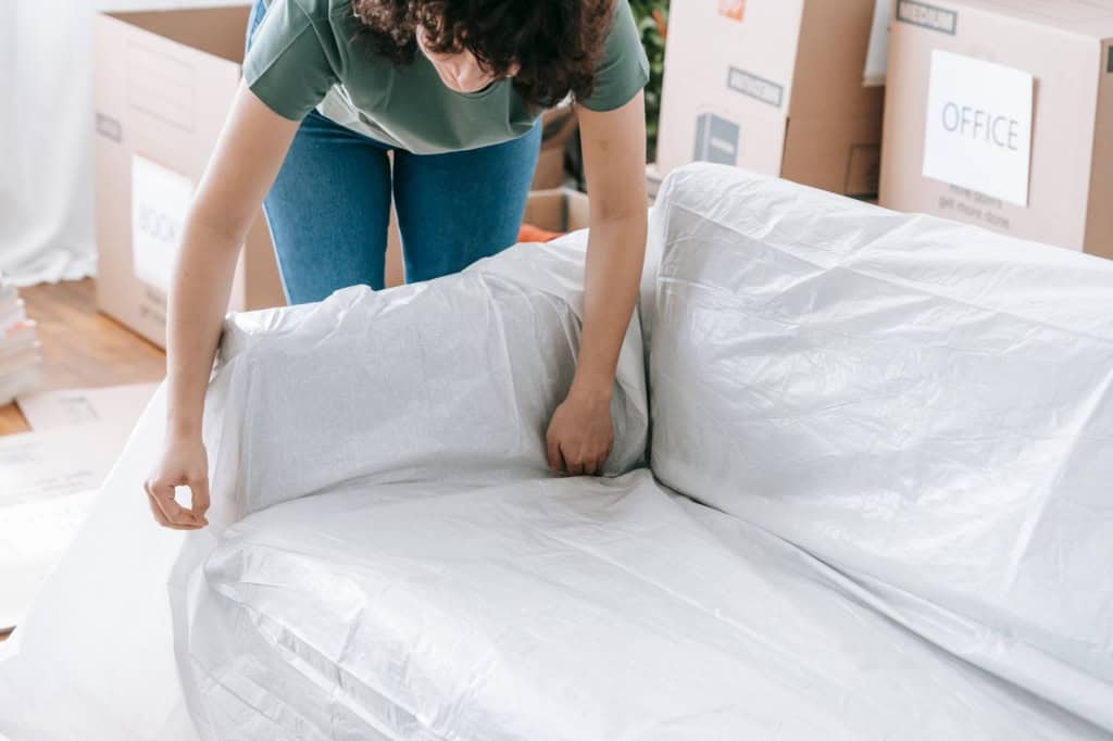 Mover wrapping furniture in protective material before loading