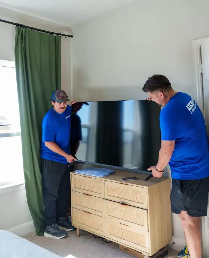 Two A1A movers moving a TV console in a living room